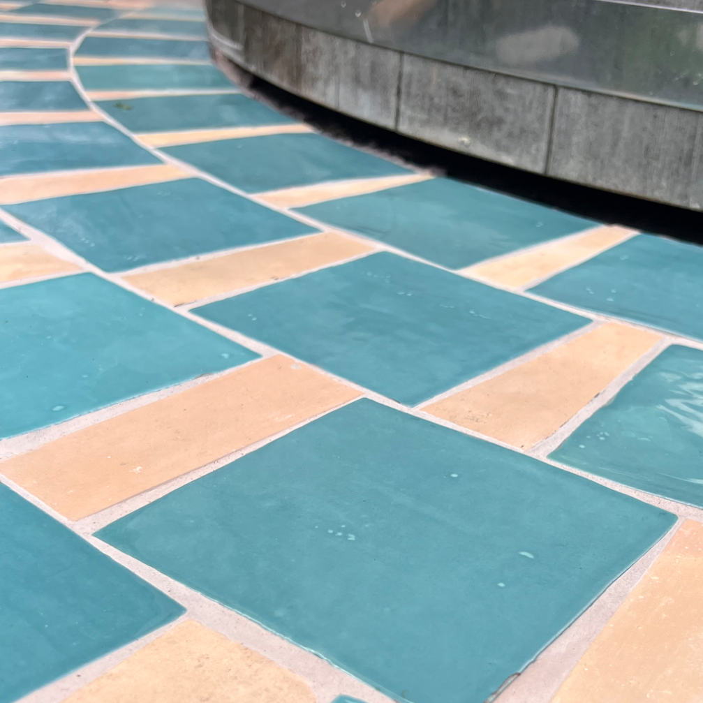 mosaïque réalisée avec des restes de carrelage pour habiller la dalle béton d'un bain nordique. joint teinté sur-mesure